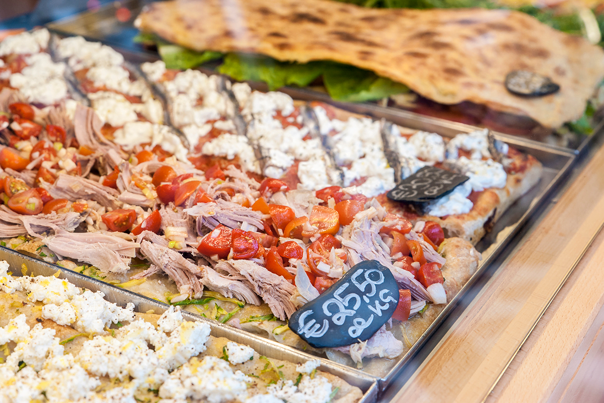Various pizza al taglio in a display case