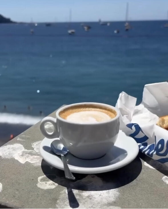 cup of cappuccino on ledge by the seaside in Italy
